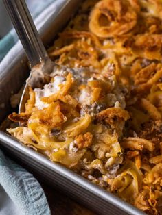 a casserole dish with cheese and onion rings in it, ready to be eaten