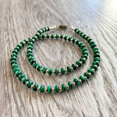 This crystal necklace is versatile and chic, this 13.5" strand of Tiny Oval-Shaped Malachite Beads paired with dainty 14k Gold Plated accents isn't just a choker necklace--it effortlessly doubles as a layered bracelet! With its adaptable length, this piece easily wraps around the wrist, creating a stunning layered bracelet that exudes sophistication and style. The petite 2mm oval-shaped Malachite beads, showcasing their natural beauty, transition seamlessly from necklace to bracelet, offering yo Malachite Green, Layered Bracelet, Gifts For Christmas, Emerald City, Layered Bracelets, Crystal Necklace, Gold Filled, Choker Necklace, Wicked