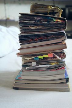 a stack of papers sitting on top of a bed