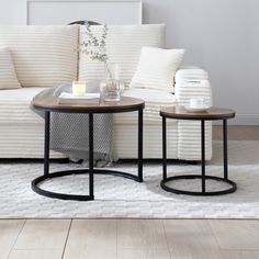 two tables sitting next to each other on top of a white rug in front of a couch