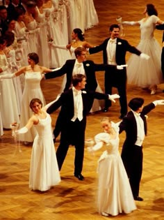 a group of people standing on top of a wooden floor in front of a crowd