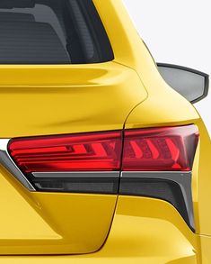 the rear end of a yellow car with its tail lights turned to show it's brake light