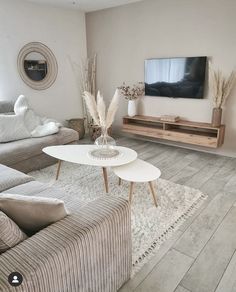 a living room filled with furniture and a flat screen tv on top of a wooden stand