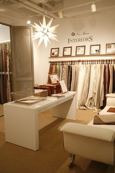 the interior of a clothing store with clothes on display