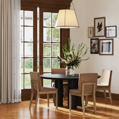 a dining room table with four chairs and a vase on the table in front of it