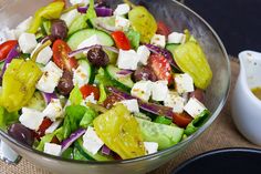 a salad with cucumbers, tomatoes, olives and feta cheese in a bowl