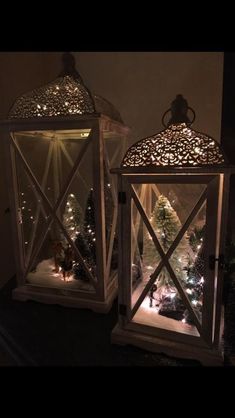 two lanterns are lit up with christmas lights