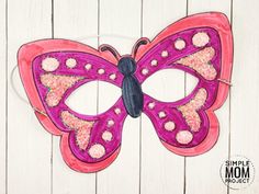 a pink and purple butterfly mask sitting on top of a white wooden table with text overlay that says simple mom project