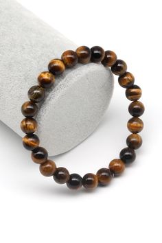 This stunning natural Tiger's Eye bracelet is crafted with beautifully polished brown gemstone beads, each displaying the mesmerizing chatoyancy for which Tiger's Eye is renowned. Known as the "stone of courage," Tiger's Eye is believed to enhance self-confidence, focus, and mental clarity, making this bracelet not only a striking accessory but also a powerful tool for personal growth and protection. Features: Natural Tiger's Eye Stones: Handpicked, high-quality beads with unique golden-brown hues and captivating sheen. Size: Available in various sizes to ensure a comfortable fit. Durable Elastic Cord: Designed for easy wear and long-lasting use. Unisex Design: Perfect for both men and women, ideal for everyday wear or special occasions. Benefits: Boosts Confidence: Tiger's Eye is known fo Tigers Eye Bracelet, Brown Gemstone, Tiger Eye Bracelet, Chakra Jewelry, Handmade Jewelry Gift, Perfect Gift For Him, Tiger Eye Stone, Eye Bracelet, Beads Handmade