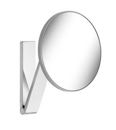 a mirror that is on the wall next to a light fixture with a curved arm