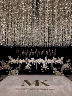 a large chandelier hanging from the ceiling above a table with flowers and candles