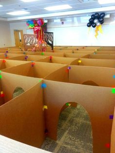 a room filled with lots of cardboard boxes and colorful confetti on the walls