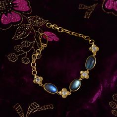 This lovely labradorite and moonstone bracelet has been handmade in our workshops.   The bracelet is made in sterling silver coated with 24ct gold vermeil, and is adjustable.  It has a matching pendant and ring.  Central motif dimensions are 9mm x 11mm. Sterling silver coated with 24ct gold vermeil embedded with labradorite and moonstone  Store your jewellery in a soft lined pouch or box separately so they don't damage each other.  Precious metals naturally tarnish with exposure to air as well a Engraved Flower, Labradorite Bracelet, Statement Jewellery, Moonstone Bracelet, Earrings Pendant, Silver Coat, Bracelet Women, Couture Jewelry, Old Jewelry