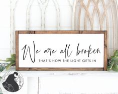 we are all broken that's how the light gets in sign on mantle with potted plant