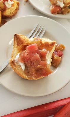 a plate with some food on it and a fork in the middle next to other plates