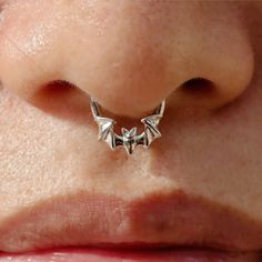 a woman's nose with an origami style nose ring on her left side