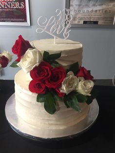 a white cake with red and white roses on top