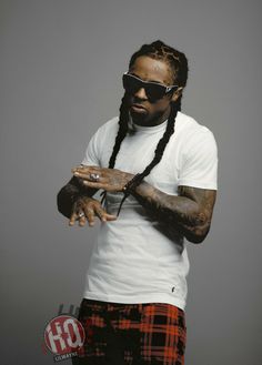 a man with dreadlocks and sunglasses on his face is holding something in his hand