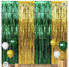 a green and gold party backdrop with balloons