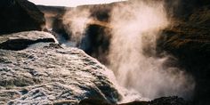 the water is flowing down the side of the cliff and into the river below it