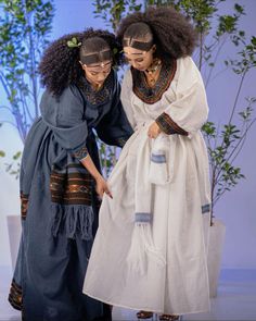 two women dressed in ethnic clothing standing next to each other