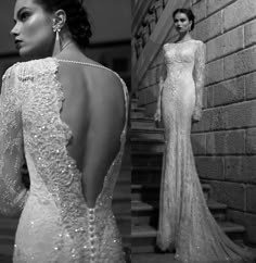 a woman in a long white dress standing next to stairs and looking back at the camera