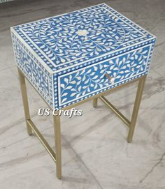 a blue and white table sitting on top of a marble floor