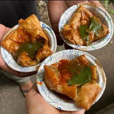 three paper plates filled with food on top of each other in front of someone's hand