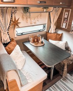 the interior of a camper with two couches and a table