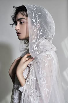 a woman wearing a veil with flowers on it