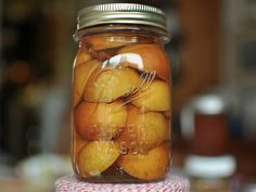 a jar filled with oranges sitting on top of a table