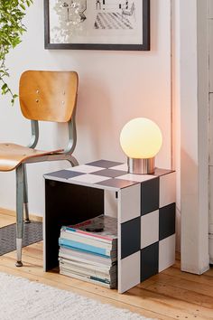 a lamp sitting on top of a table next to a chair and a book shelf