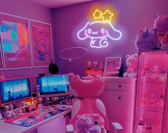 a room with pink walls and lots of stuffed animals on the desk, along with neon lights