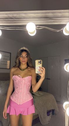 a woman in a pink corset taking a selfie with her cell phone