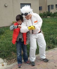 a man and boy dressed up in costumes standing next to each other on the sidewalk