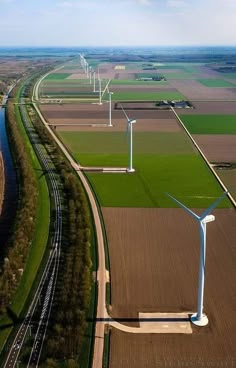 an aerial view of several wind turbines in a field