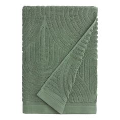 the green towels are folded on top of each other, with an intricate design in the middle