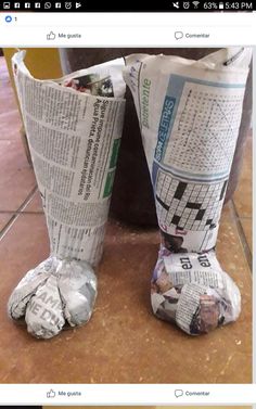 a pair of newspaper boots sitting on top of a tiled floor