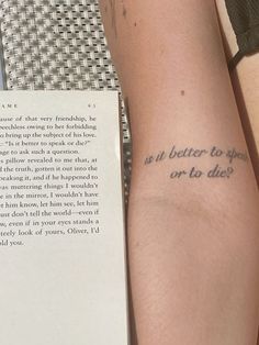 two people with tattoos on their arms reading a book