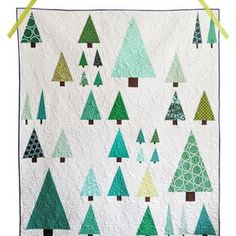 a quilted wall hanging with trees on it