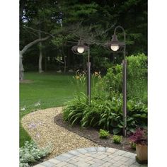 a garden with lots of plants and lights in it's center area on a brick walkway