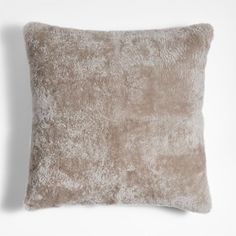 a beige pillow on a white wall