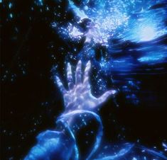 a hand reaching for something in the air with water swirling around it and bubbles coming out of its hands