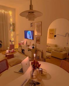 a laptop computer sitting on top of a white table in a living room filled with furniture