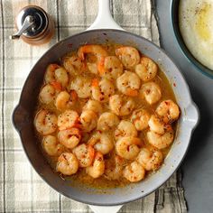 shrimp and grits in a skillet next to a bowl of mashed potatoes