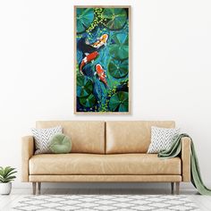 a living room with a couch, rug and painting on the wall above it is a fish pond