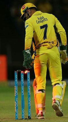 a man standing next to a cricket ball on top of a field