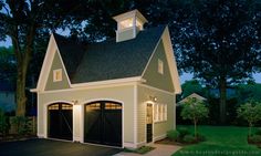 a two car garage with an attached dormer on the top floor and a steeple above it