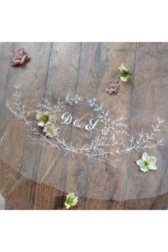 a table with flowers and the word love written in glass on it, surrounded by petals