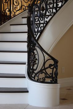 a staircase with wrought iron railing and handrail